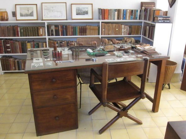 simple desk and chair, book shelves, mementos