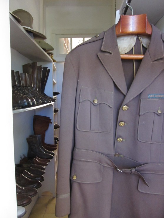 a closet filled with shoes, boots and hats and his Spanish Civil War uniform
