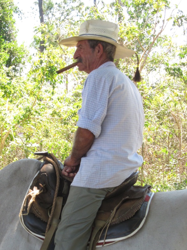 The farmer makes posing a bit more bearable by chewing a cigar.
